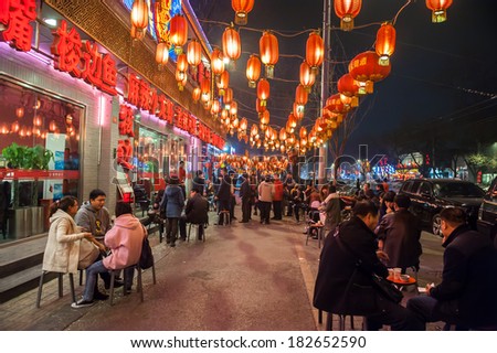 BEIJING,CHINA - MARCH 31 ,2011: People wait in front of Chinese restaurants at Gui street in Beijing,China.Most restaurants in the street are open all night.