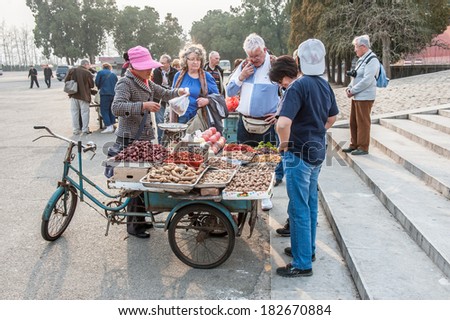 BEIJING,CHINA-MARCH 30 ,2011: Visitors buy fruits at bicycle fruit shop in Changling Tomb of Ming Dynasty Tombs in Beijing, China.