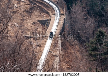 BEIJING,CHINA - MARCH 30 ,2011 : Visitor use toboggan-run slide down in motion blur   from the great wall of China at Mutianyu pass in Beijing,China.That is fast way and fun to come down.