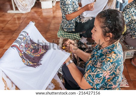 Bali, Indonesia, April 21,2010 : Balinese woman applies wax on a piece of batik  in Bali,Indonesia.Batik-making is an important part of Indonesian culture.