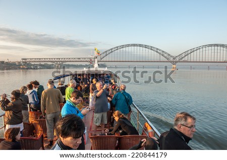 Sagaing,Myanmar-March 17,2011 : Unidentified tourists on the tourist ferry boat from Mandalay to Bagan when pass the new Sagaing Bridge in Irrawaddy river in Sagaing, Mandalay, Myanmar.