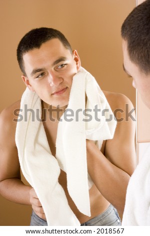 reflexion of young man in the bathroom's mirror after shaving