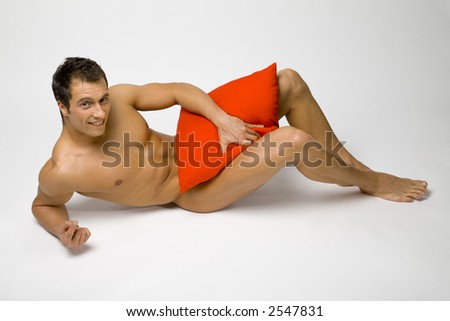 stock photo Nacked smile man lying on the floor Trying to hide his body