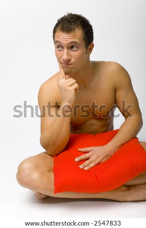 stock photo Nacked man sitting Hiding his body by pillow and thinking