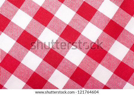 Closeup view of checked with red and white tablecloth