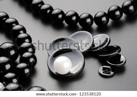 Sewing buttons and beads on the black surface. Unique concept