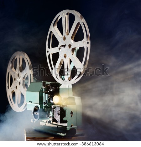 Old retro movie projector with smoke and light beam