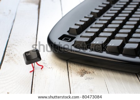 Escape key run away from a black keyboard. Concept photo