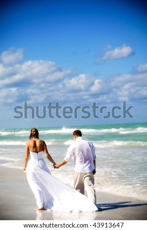 Couple walking on the beach at their destination wedding