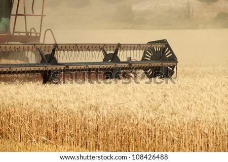 An agricultural combine cutting and harvesting wheat in the fertile farm fields of Idaho.