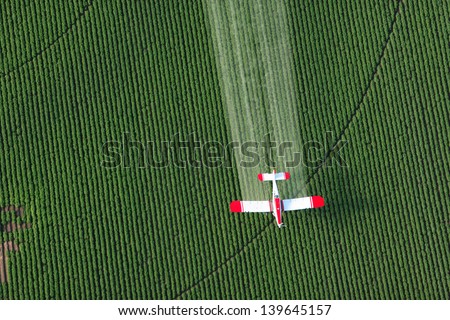 A Crop Dusting Plane Working Over A Field Of Potatoes