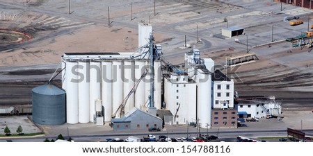 An aerial view of grain elevators for storing wheat and other cereal grains.  It is located next to a railroad siding for easy loading and unloading.