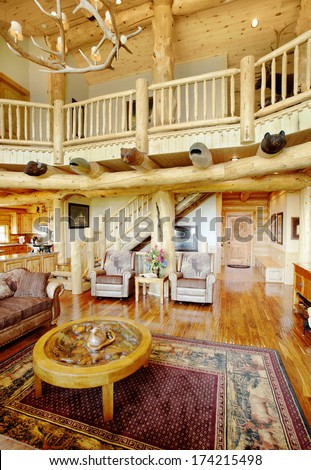 The great room in a modern log cabin, with rustic decor, and furniture.