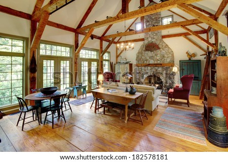 An image of a sitting room and fireplace in a primitive colonial style reproduction home. The home is built with materials reclaimed from structures built in the late 1700\'s.