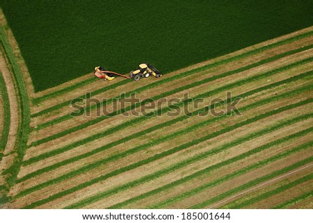 Blackfoot, Idaho, USA Aug. 7, 2012 An aerial view of farm machinery harvesting hay in an alfalfa field