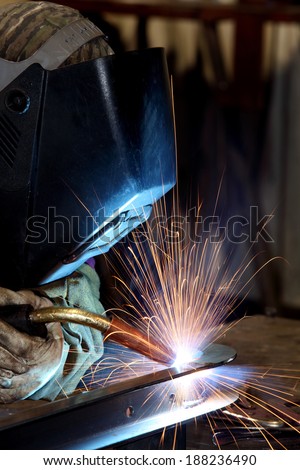 A welder welding the top on a pressure vessel
