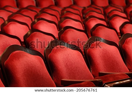 Rows of red velvet theater seats in an old Vaudeville style theater.