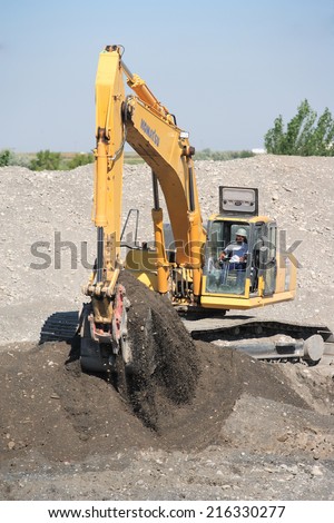 Shelly, ID Sept, 5, 2014 A worker using a large backhoe digs a large hole for the construction of a new sewage treatment facility.  The cost of this facility is paid for in part by government grants.