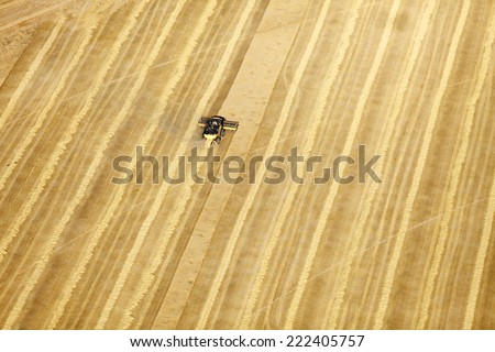 An aerial view of farm machinery in the field harvesting wheat