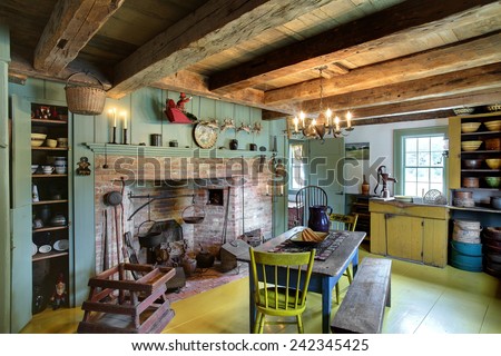 The kitchen, dining room and fireplace in a 17th century primitive colonial style home.  This home dates to before the American revolutionary war, and contains antiques from the late 18th century.