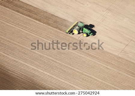 American Falls, Idaho, USA Apr. 17, 2015 An aerial view of farm machinery planting potatoes in the fertile farm fields of Idaho.