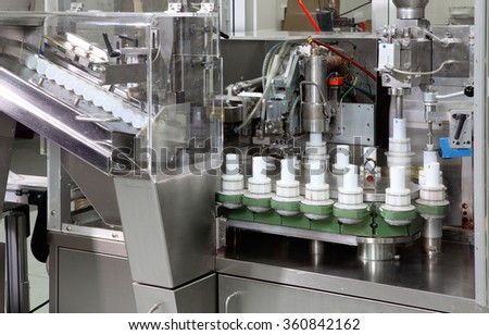 A tube filling machine in a cosmetics factory.