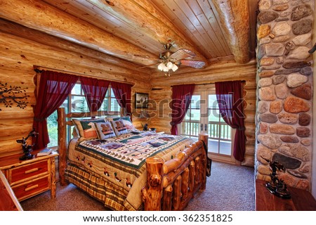 The interior of a bedroom in a modern yet rustic log cabin in the mountains.