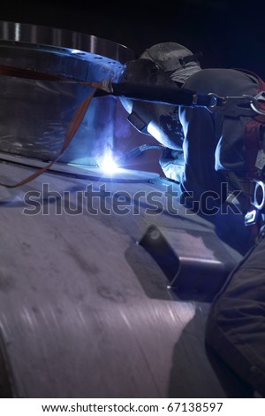 A welder welding a port on a pressure vessel.