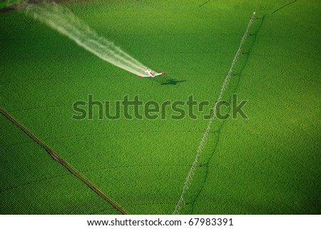 Aerial View of a crop duster spraying a farm field