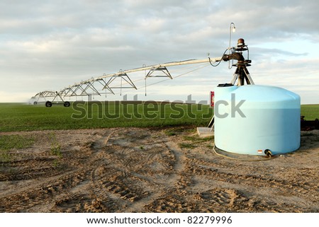A wheat field irrigated with a center pivot sprinkler system.  It is viewed from the pivot end, and shows a mix tank with ag chemicals ready to be combined with the irrigation water.