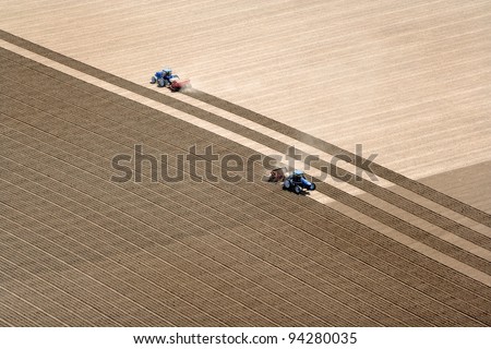 An overhead view of farmland being plowed and planted.