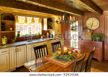 An image of a sitting room and fireplace in a primitive colonial style reproduction home.  The home is built with materials reclaimed from structures built in the late 1700\'s.