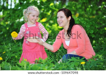 mother and daughter playing  on grass. spring day
