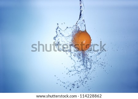 big orange in splash of water isolated