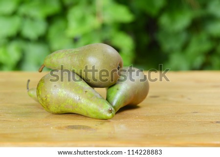 three fresh pears on wooden table