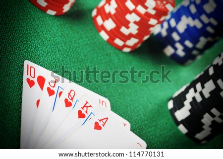 different color chips for gambling and playing cards on green