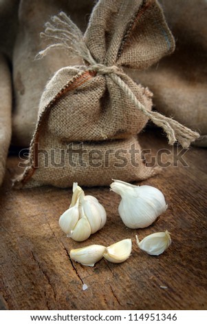 jute sack with ripe garlic  on wooden board