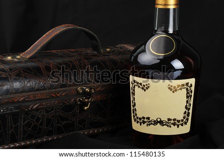 Cognac bottle near to  leather case  background