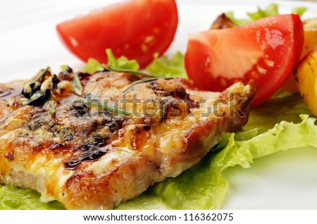 fried meat, baked potatoes and slices of tomato