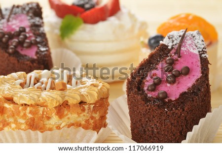 Small  cakes  with cream and  berries on bamboo table cloth