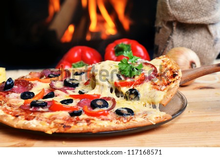 Pizza lifting slice with pepperoni and olives Pizza lifting slice with pepperoni and olives