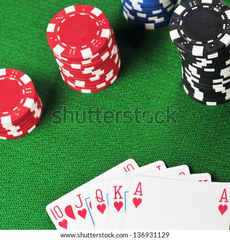 different color chips for gamblings and playing cards on green