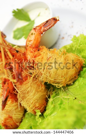 Deep fried shrimp on lettuce leaves with white sauce