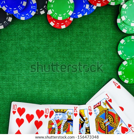 different color chips for gambling and playing cards on green