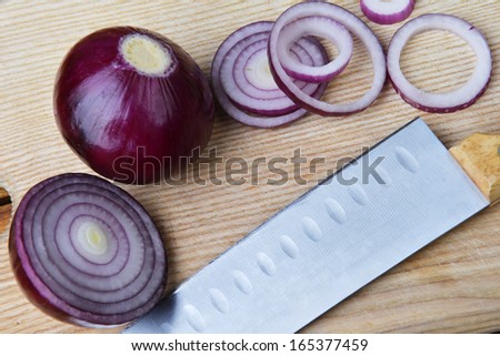 slices of red onions on wooden cutting board