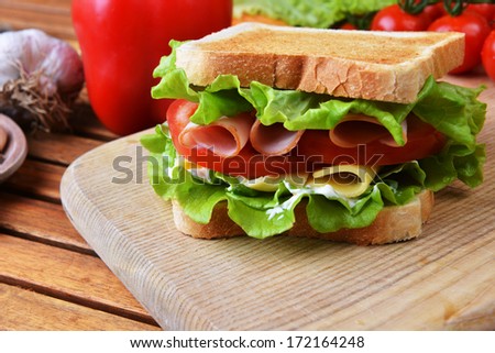 Fresh And Tasty Sandwich On Wooden Cutting Board