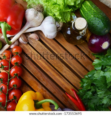 fresh vegetables and olive oil on wooden background