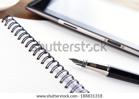 open notebook, mobile  phone and black  pen on white background