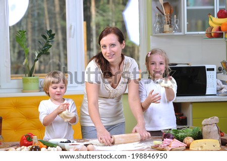 mother with children prepare dough for pizzas