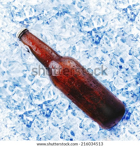 brown beer bottle in ice bucket with condensation